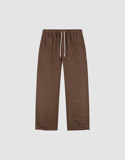 The LFDY Lightweight Jogger by LIVE FAST DIE YOUNG features a wide fit, straight-leg design in brown French Terry with an elastic waistband, white drawstring, and side pockets. Shown flat on a plain light background. | plain