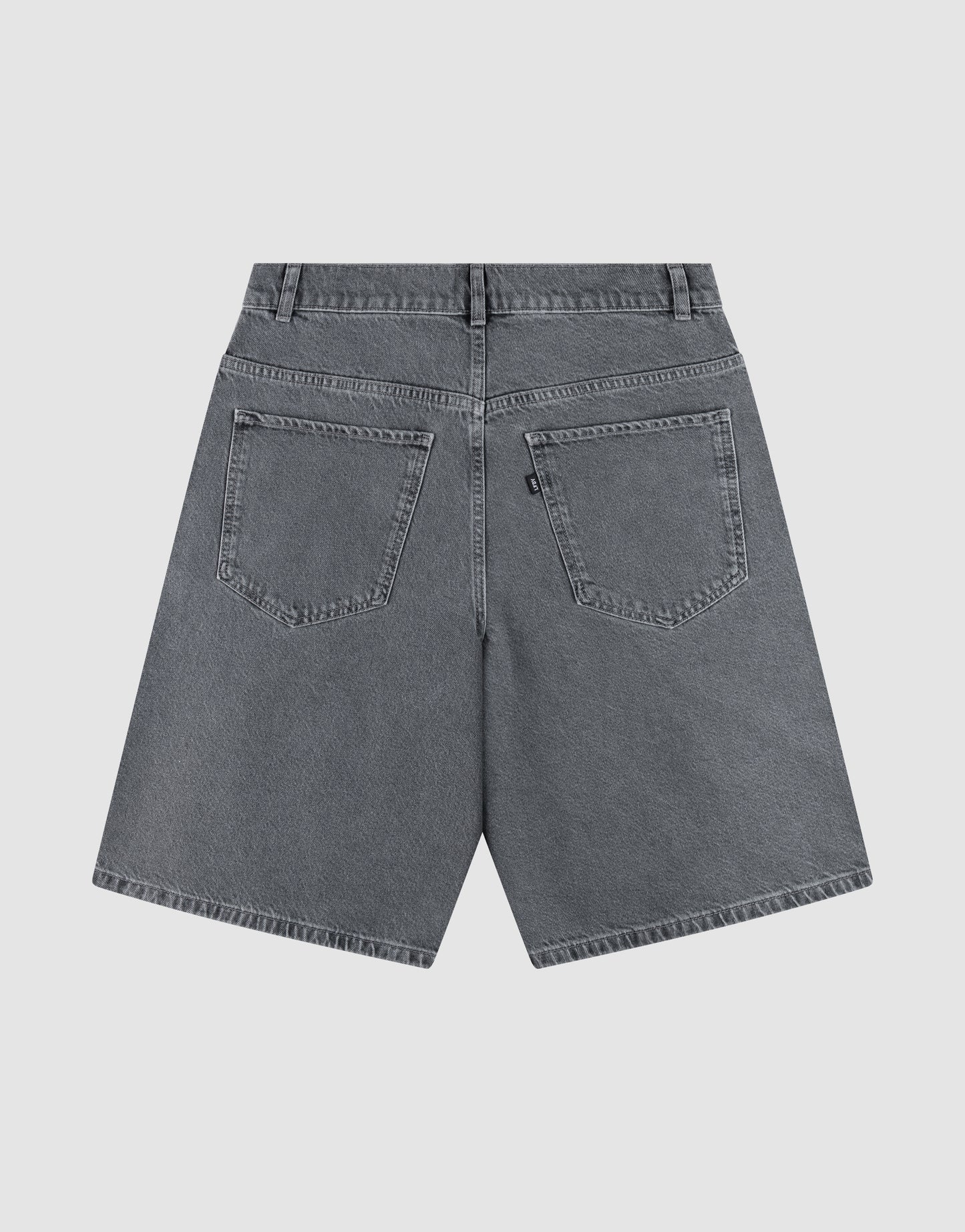 Back view of LFDY Jorts by LIVE FAST DIE YOUNG: gray denim baggy shorts with wide straight legs, belt loops, two large back pockets, and a small black tag on the right pocket, shown on a plain light background.