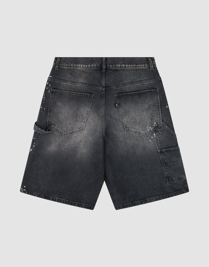 The LIVE FAST DIE YOUNG Carpenter Jorts are black denim shorts in a Baggy Fit, shown from the back with two rear pockets, a left tool loop, extra right side pockets, and unique white paint splatter details on both sides.