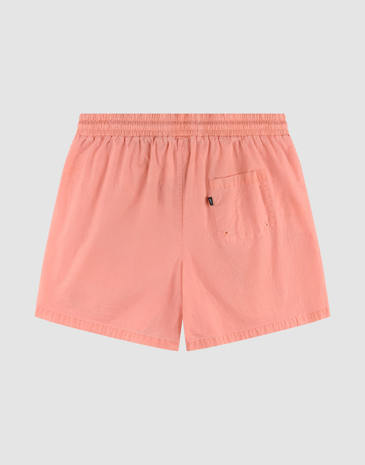 The Live Fast Swim Shorts by LIVE FAST DIE YOUNG feature a tinted peach wash, broad elastic waistband, single back pocket with a small black tag and two metal eyelets, displayed flat on a light gray background.