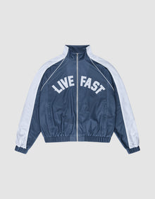 The LFDY Arch Trackjacket by LIVE FAST DIE YOUNG is a blue and white zip-up jacket with an oversize fit, featuring "LIVE FAST" in bold white letters across the chest and seitliche Eingrifftaschen for convenience. | plain