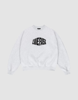 The LFDY Emblem Sweater by LIVE FAST DIE YOUNG is a light gray Oversize Fit crewneck with bold, black “LIVE FAST” lettering on the chest, shown laid flat on a white background. | plain