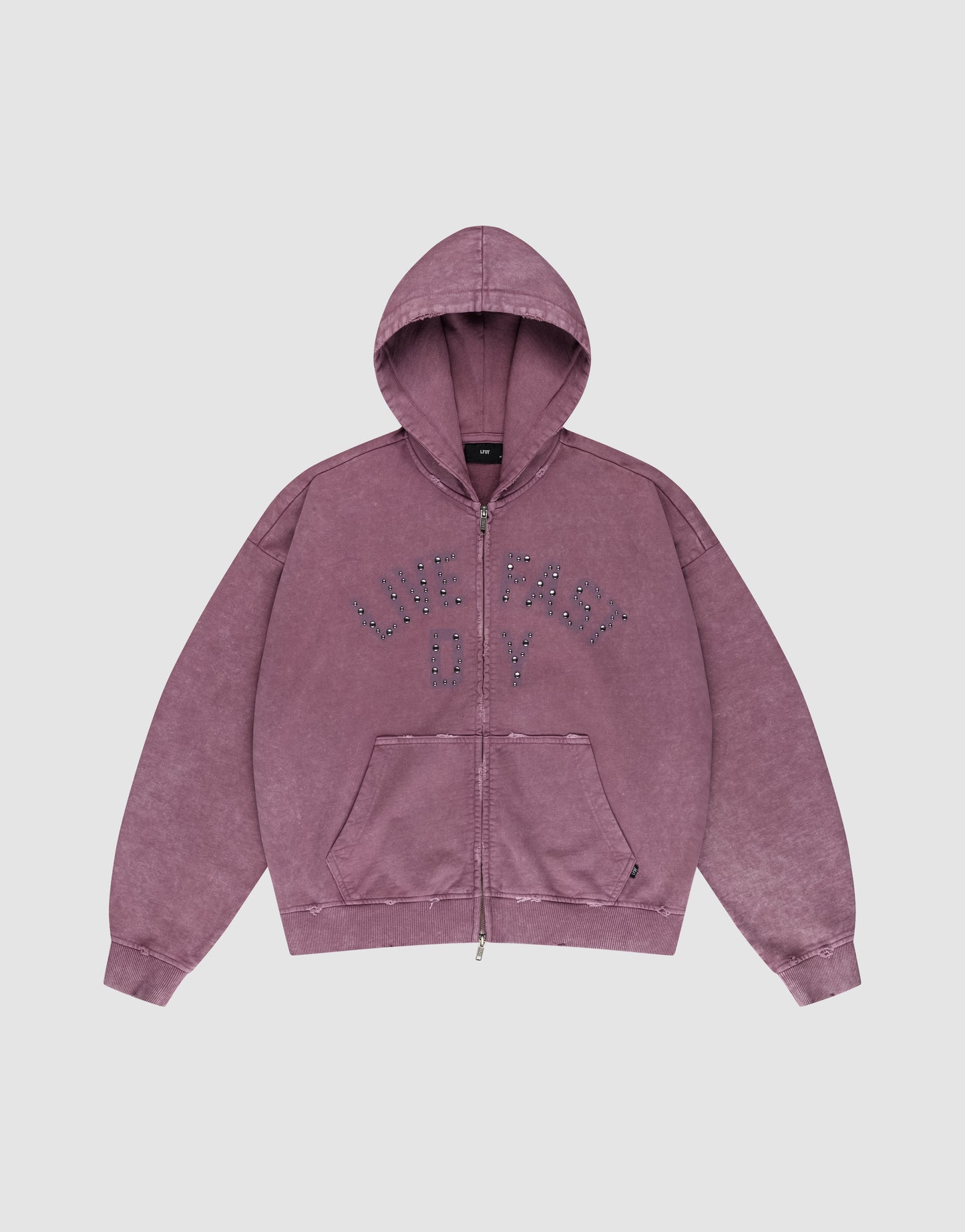 The LIVE FAST DIE YOUNG Live Fast Rivet Hooded Zip is a purple, oversized hoodie with a zip front, hood, and front pockets. "LIVE FAST OY" is boldly printed in dotted letters on the chest. Features a vintage faded look with subtle distressing.