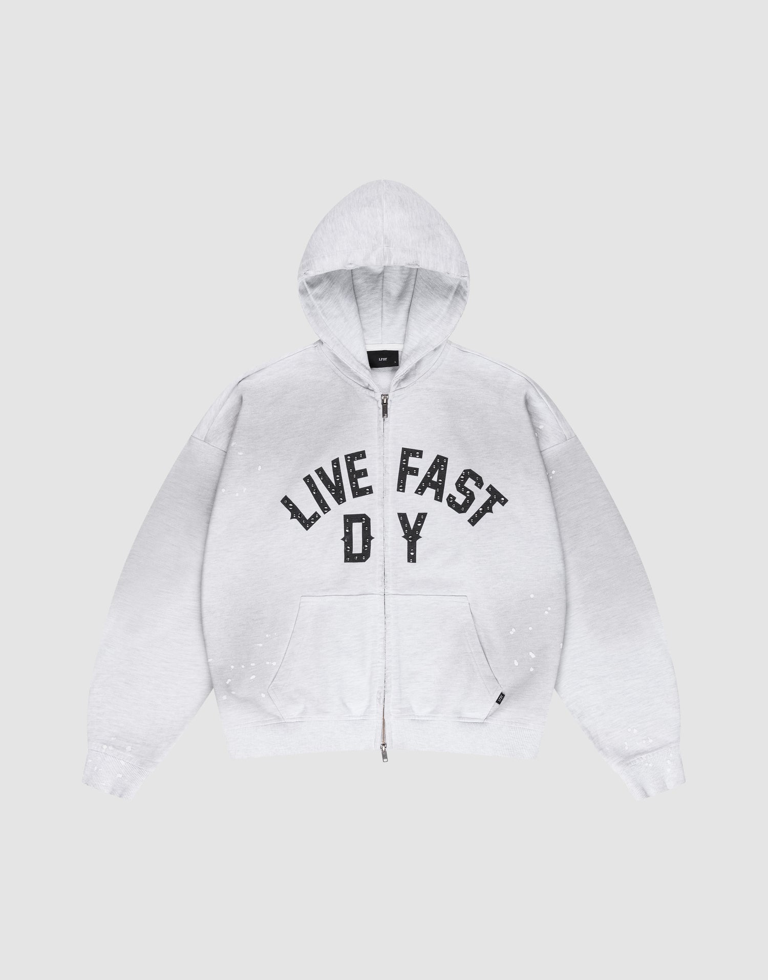 The Live Fast Rivet Hooded Zip by LIVE FAST DIE YOUNG is a light gray, oversize-fit hoodie with front pockets, a hood, black “LIVE FAST D Y” chest text, and unique hand-applied white paint splatters. Made from 100% Baumwolle. | plain