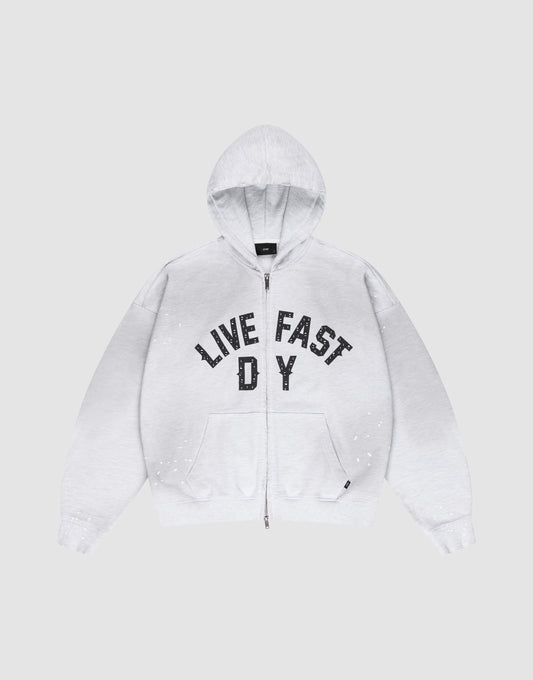 The Live Fast Rivet Hooded Zip by LIVE FAST DIE YOUNG is a light gray, oversize-fit hoodie with front pockets, a hood, black “LIVE FAST D Y” chest text, and unique hand-applied white paint splatters. Made from 100% Baumwolle. | plain