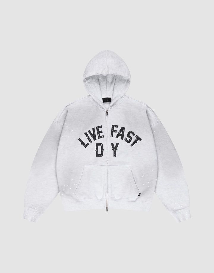 The Live Fast Rivet Hooded Zip by LIVE FAST DIE YOUNG is a light gray, oversize-fit hoodie with front pockets, a hood, black “LIVE FAST D Y” chest text, and unique hand-applied white paint splatters. Made from 100% Baumwolle. | plain