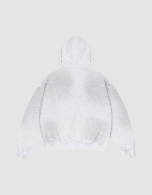The LIVE FAST DIE YOUNG Live Fast Rivet Hooded Zip in light gray is laid flat, back up, on a matching background. It features an oversize fit and hand-applied spray effect with scattered white specks.