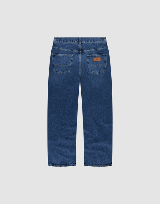A pair of Wide Denim jeans by LIVE FAST DIE YOUNG, shown from the back with two rear pockets, visible stitching, a brown leather patch on the right pocket, and made of 100% Baumwolle against a plain light gray background.