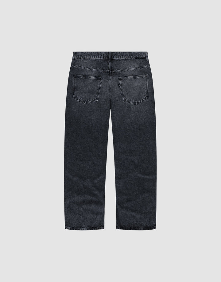 Back view of the LFDY Baggy Denim by LIVE FAST DIE YOUNG, crafted from 100% Baumwolle in dark-wash with a wide straight leg, two back pockets, no visible distressing, shown on a plain light gray background.