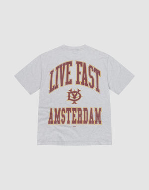 The Live Fast Amsterdam Tee by LIVE FAST DIE YOUNG is an oversized, light gray t-shirt made from 100% Baumwolle. It features large maroon and gold "LIVE FAST" text above a crest and bold "AMSTERDAM" lettering on the back. | plain