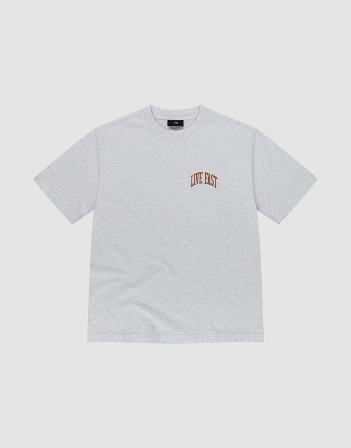 The Live Fast Amsterdam Tee by LIVE FAST DIE YOUNG is a light gray oversized short-sleeve t-shirt made from 100% cotton, featuring small brown "LIVE FAST" lettering on the left chest, shown on a white background.