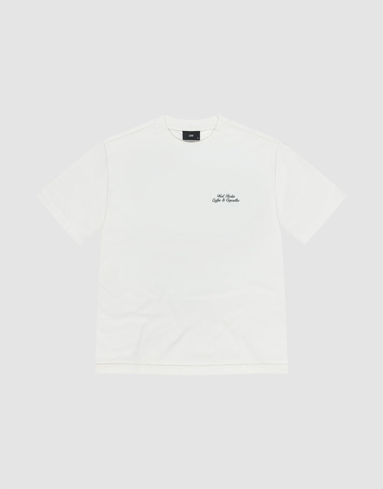 The Live Fast Coffee Tee by LIVE FAST DIE YOUNG is an oversize fit, short-sleeve white t-shirt with a small black logo and text on the left chest, made from 100% Baumwolle and shown on a light gray background.