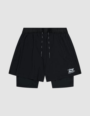 The LIVE FAST DIE YOUNG Live Fast Performance Running Shorts feature an overlapping design with built-in tights, elastic waistband with drawstrings, and a small white Live Fast Branding logo on the lower left leg, shown on a plain light gray background.| plain
