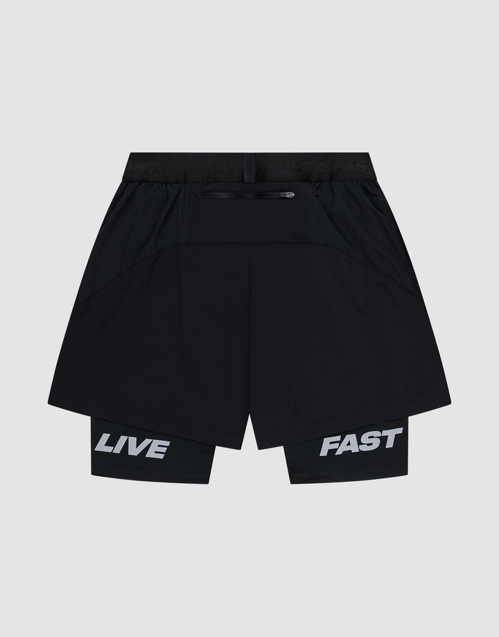 LIVE FAST DIE YOUNG Live Fast Performance Running Shorts feature an overlapping black design with “LIVE” on the left inner leg and “FAST” on the right in bold white. Regular fit, shown on a plain light background.