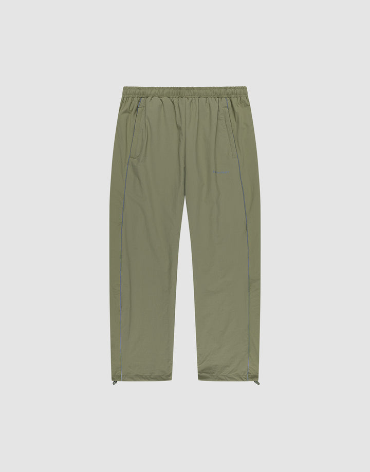 The Live Fast Trackpants by LIVE FAST DIE YOUNG are light olive green, wide-fit, lightweight pants with an elastic waistband, side pockets, subtle seam details, ankle zippers, and a reflective logo print. Shown on a plain white background. | plain