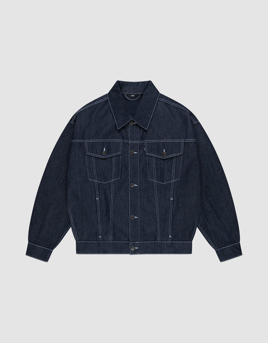 Die LFDY Denim Jacket von LIVE FAST DIE YOUNG aus 100% Baumwolle präsentiert sich in dunklem Raw-Denim mit spitzem Kragen, Knopfleiste, Brusttaschen mit Klappen und weißen Kontrastnähten auf hellgrauem Hintergrund. | plain