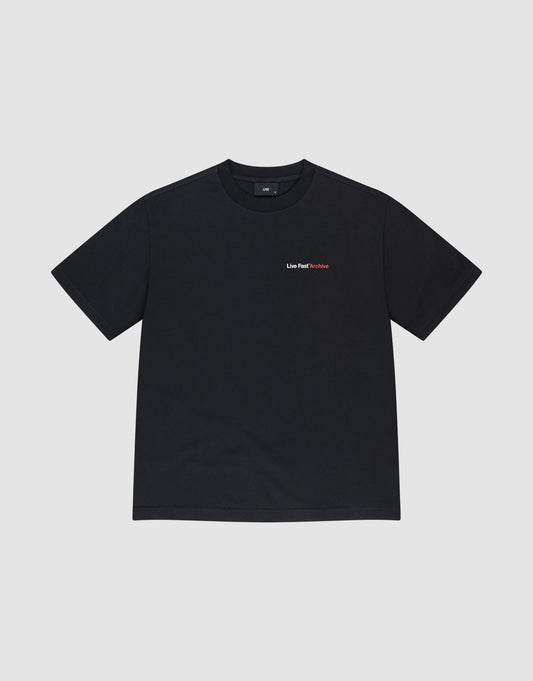 The LFDY F*ck Phones Tee by LIVE FAST DIE YOUNG is a black oversize fit cotton T-shirt featuring “Live Fast” in white and “Fetiche” in red on the left chest, displayed against a plain light gray background.
