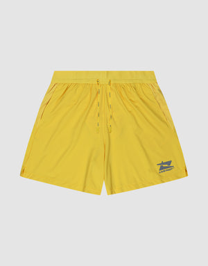The LIVE FAST DIE YOUNG Live Fast Performance Shorts in yellow feature lightweight fabric, an elastic waistband with drawstring, and a small reflective LIVE FAST logo on the lower left leg, shown against a plain light background. | plain