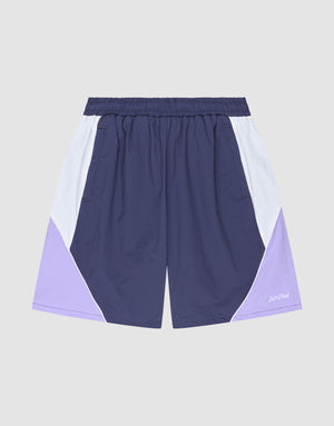 The LIVE FAST DIE YOUNG Basic Nylon Trackshorts feature a regular fit, elastic waistband, color-block design in navy, white, and light purple, plus a subtle logo stitch on a plain gray background. | plain