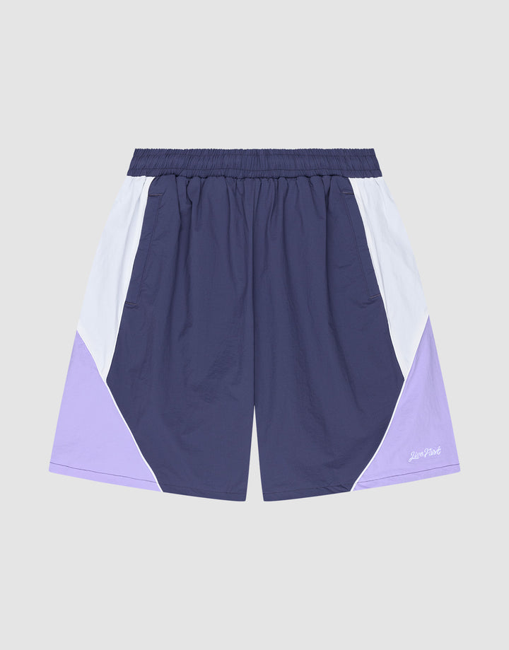 The LIVE FAST DIE YOUNG Basic Nylon Trackshorts feature a regular fit, elastic waistband, color-block design in navy, white, and light purple, plus a subtle logo stitch on a plain gray background. | plain