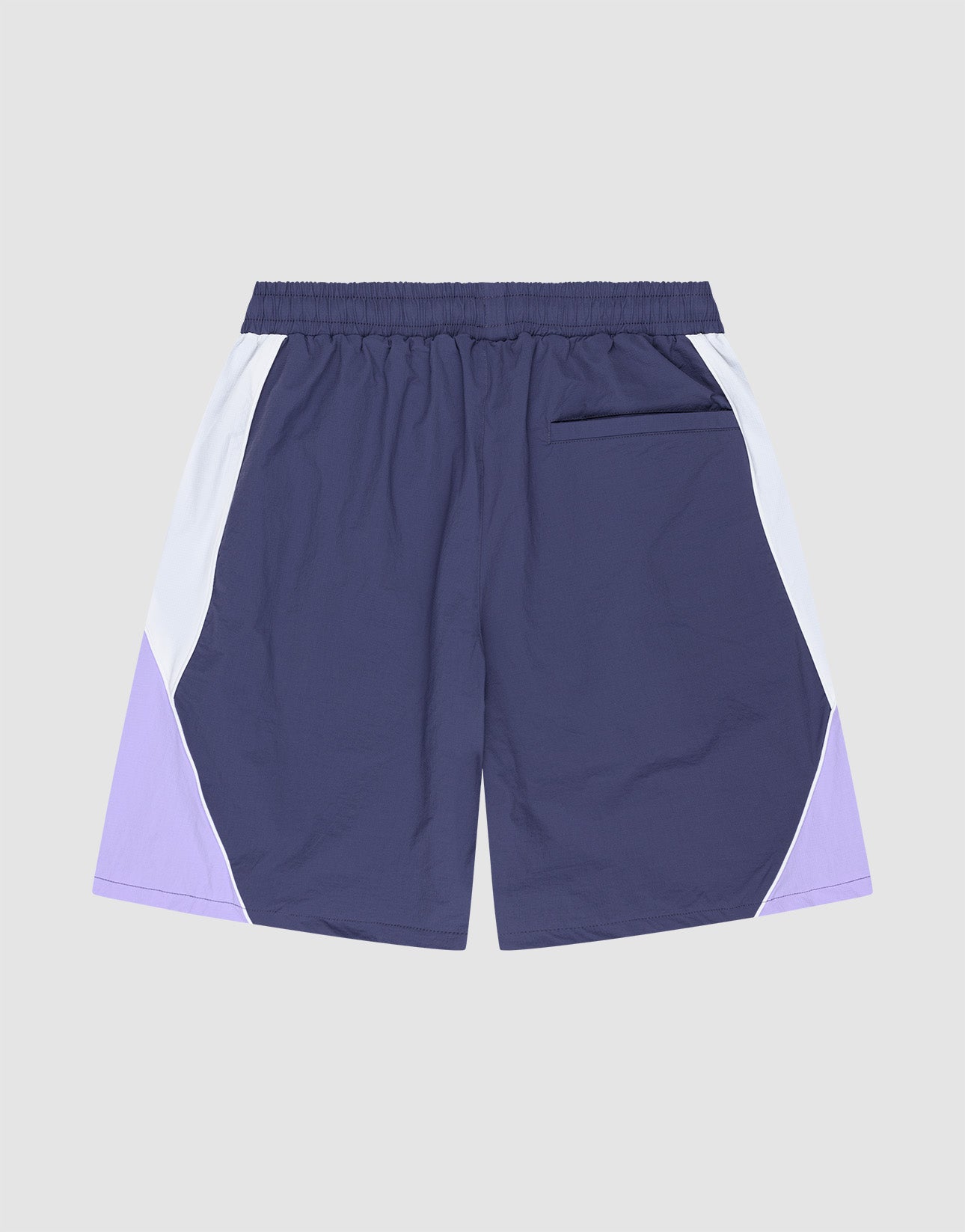 The LIVE FAST DIE YOUNG Basic Nylon Trackshorts feature a Regular Fit, elastic waistband, purple shade with white side panels, zippered back pocket, and subtle logo stitching, showcased on a light gray background.