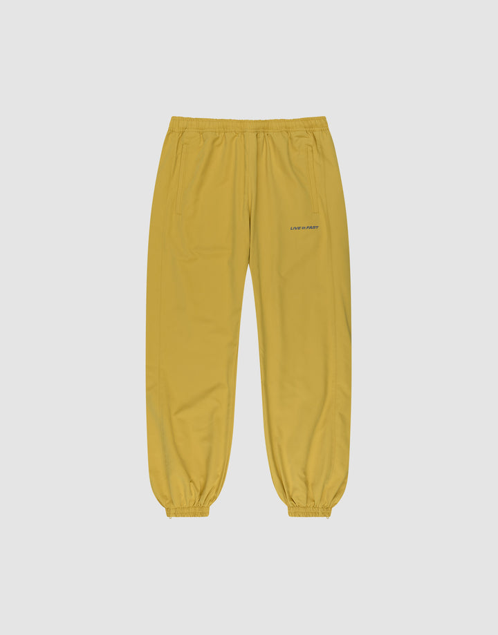 LFDY Trackpants by LIVE FAST DIE YOUNG in yellow with elastic waistband and cuffs, side pockets, and reflective LOVERBOY print on the left thigh, shown on a plain light gray background. | plain