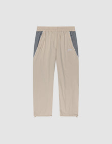LIVE FAST DIE YOUNG Basic Nylon Trackpants in beige with grey side panels, elastic waistband, side pockets, and elasticated cuffs, displayed flat on a plain light background. | plain
