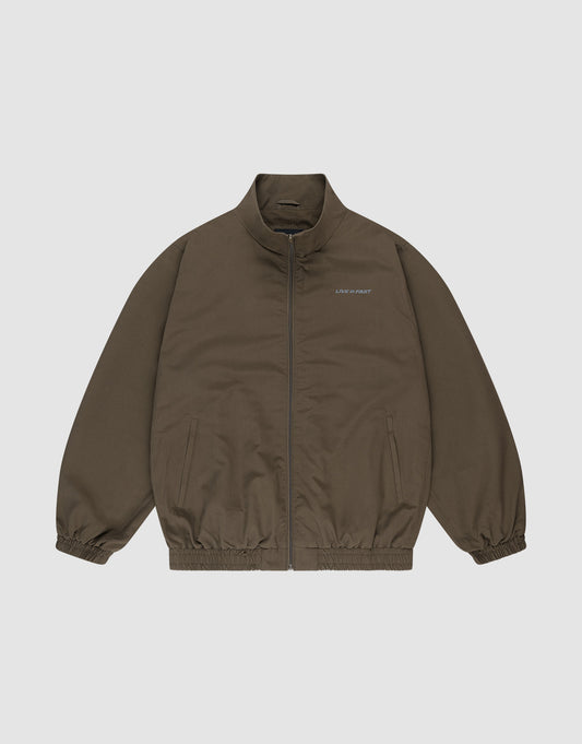 The LFDY Trackjacket by LIVE FAST DIE YOUNG is a brown zip-up with a stand collar, elastic cuffs and hem, oversize fit, two side pockets, and small white "LIMPIDUNIT" text on the left chest. Displayed on a plain white background. | plain