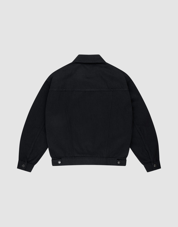 Die LFDY Denim Jacket von LIVE FAST DIE YOUNG ist eine schwarze Oversize-Jeansjacke aus 100% Baumwolle mit gerader Rückenpasse, Knopfmanschetten und verstellbaren Taillenlaschen auf hellem grauem Hintergrund.