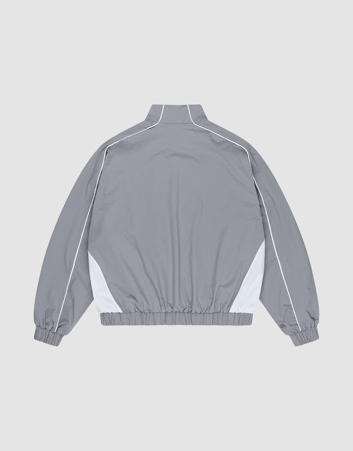 The Basic Nylon Trackjacket by LIVE FAST DIE YOUNG is a light gray Regular Fit windbreaker with white side accents and piping, shown from the back. Features a high collar, elastic cuffs and hem, plus subtle Logo-Stick detailing.