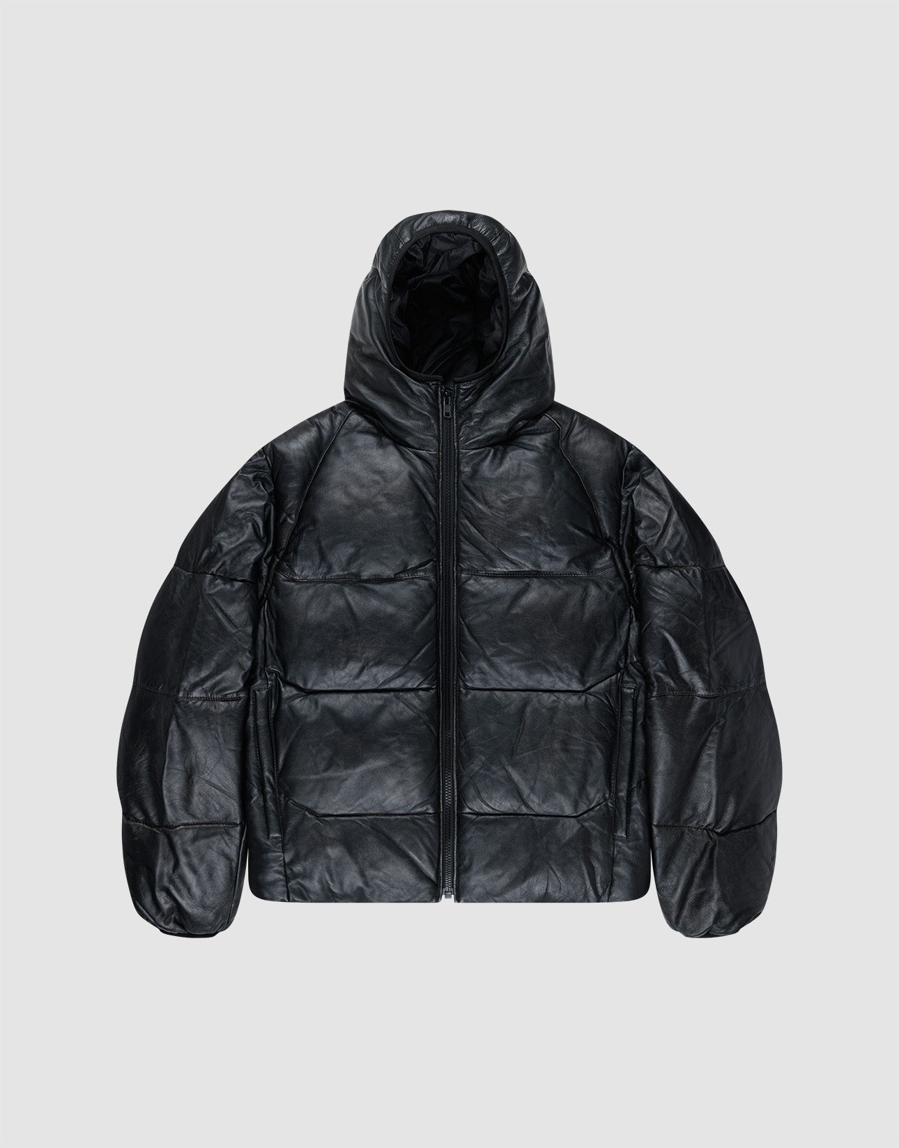 The Live Fast Leather Puffer Jacket by LIVE FAST DIE YOUNG is a black, oversized, hooded puffer made from shiny leather-like material with an embossed Live Fast logo and front zipper, shown on a plain light gray background.
