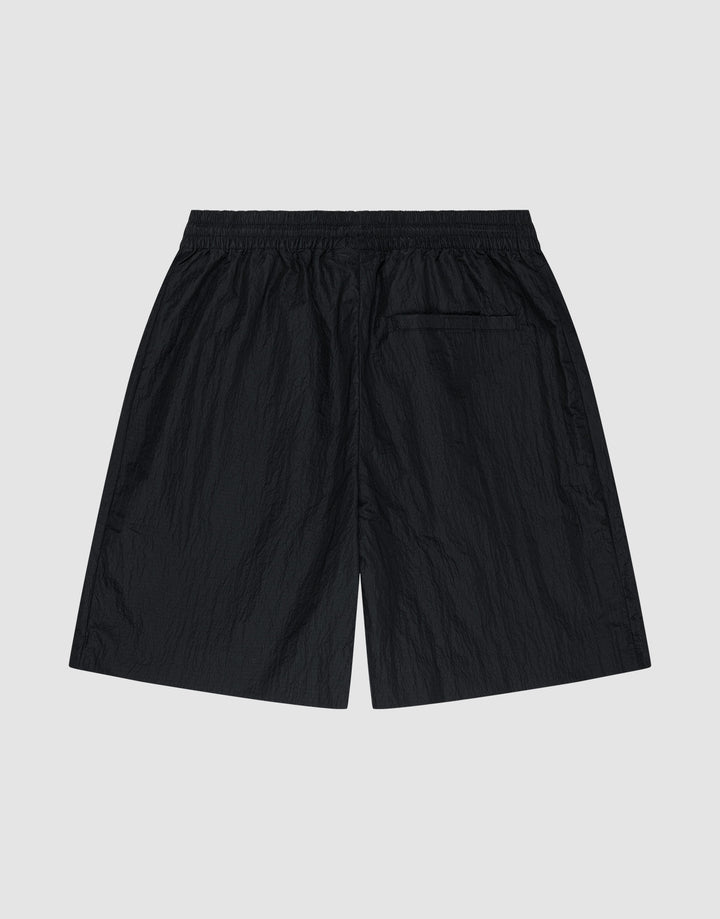 LIVE FAST DIE YOUNG’s Live Fast Nylon Shorts in black feature an oversized fit, an elastic waistband, and a single back pocket. Shown flat on a light gray background with the back view visible.