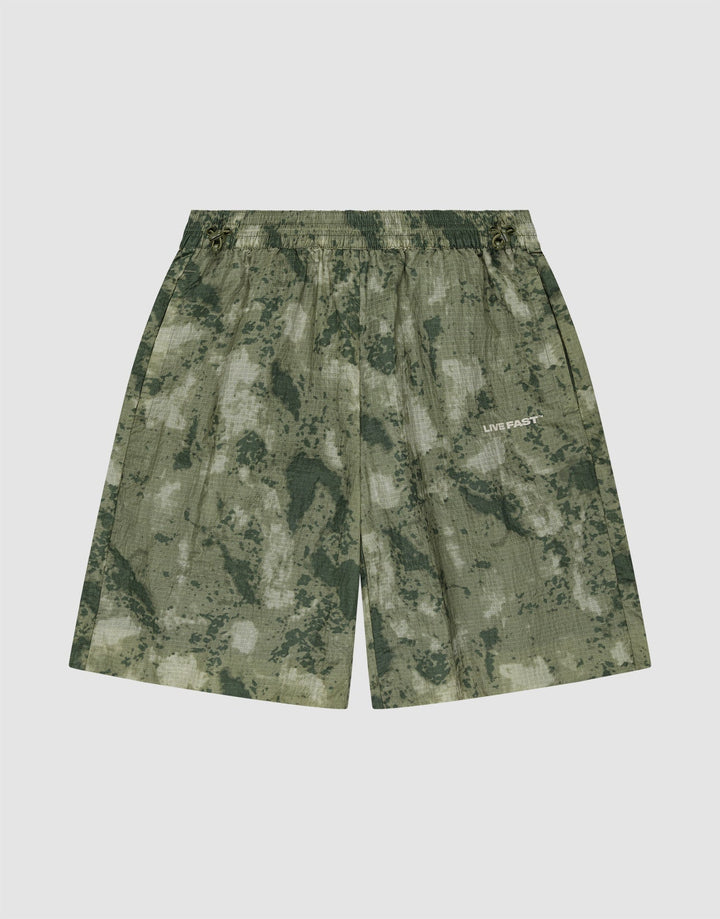 The LIVE FAST DIE YOUNG Live Fast Nylon Shorts feature a green camouflage pattern, elastic waistband, and subtle LIVE FAST silicone print on the right leg, displayed against a plain white background. | plain