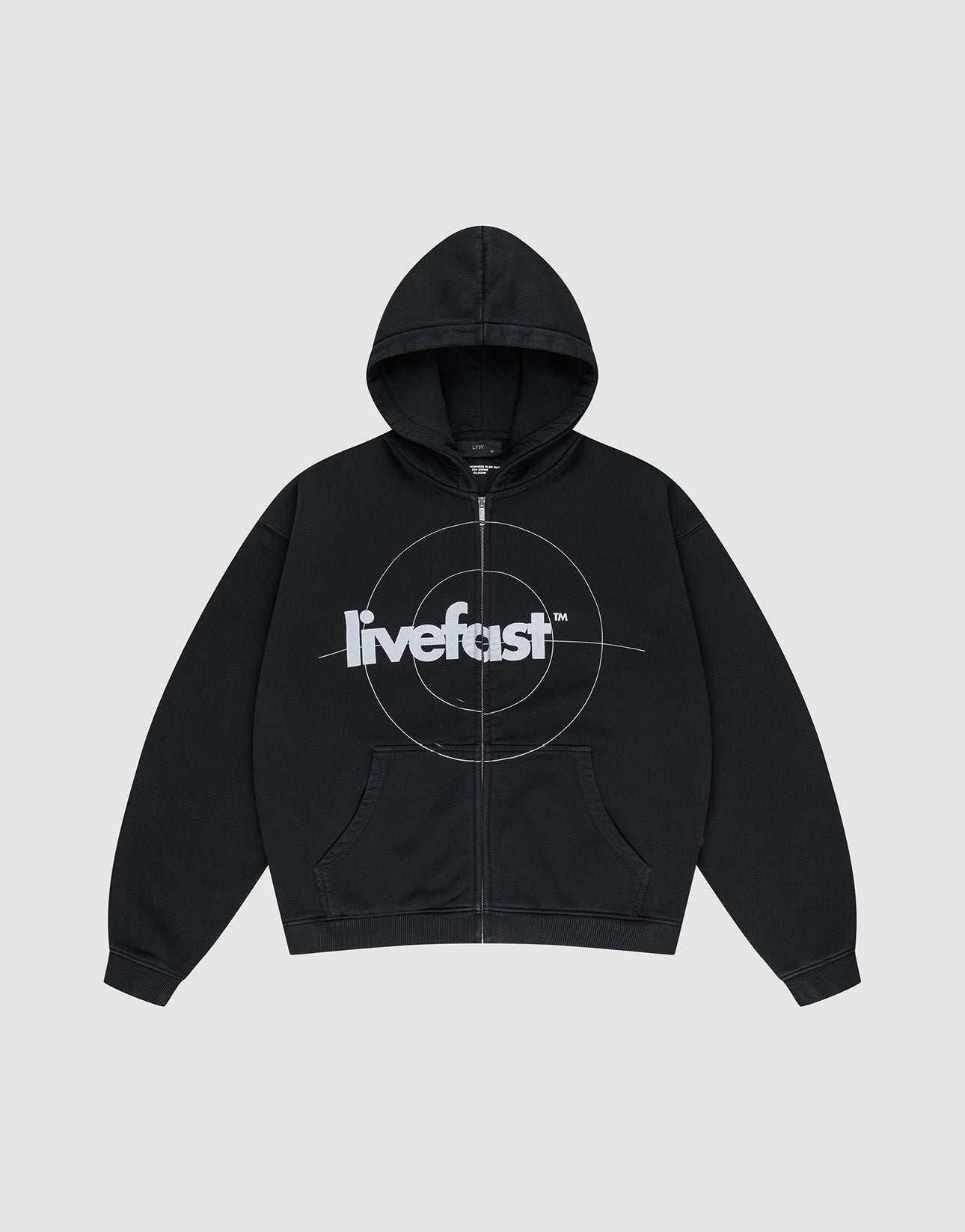 The LIVE FAST DIE YOUNG Live Fast Target Hooded Zip is a black oversized hoodie with front pockets, a hood, and bold "livefast" text over a circular chest design, displayed on a plain light gray background.