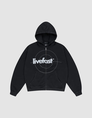 The LIVE FAST DIE YOUNG Live Fast Target Hooded Zip is a black oversized hoodie with front pockets, a hood, and bold "livefast" text over a circular chest design, displayed on a plain light gray background.