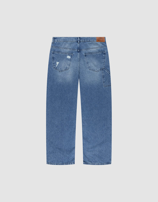 Back view of LIVE FAST DIE YOUNG Oversize Ripped Denim: blue, baggy fit, straight leg, two back pockets with slight fading and minor distressing on one pocket, plus a brown patch label on the waistband.