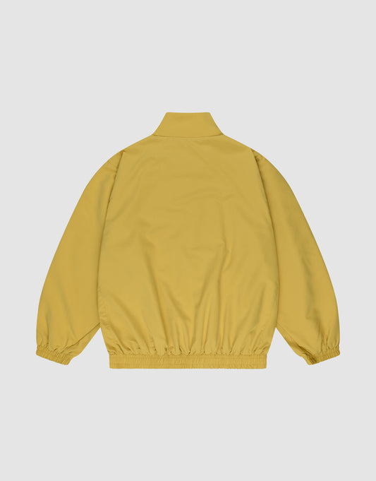 The LFDY Trackjacket by LIVE FAST DIE YOUNG is shown from the back in mustard yellow, with an oversize fit, high collar, elastic cuffs and waistband, against a plain light gray background.