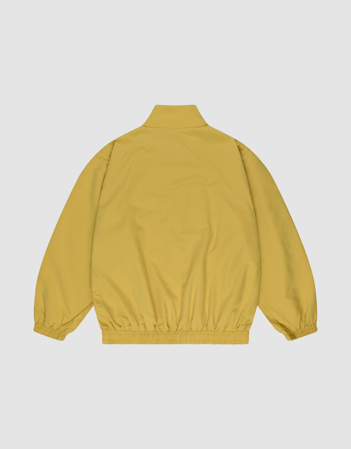 The LFDY Trackjacket by LIVE FAST DIE YOUNG is shown from the back in mustard yellow, with an oversize fit, high collar, elastic cuffs and waistband, against a plain light gray background.