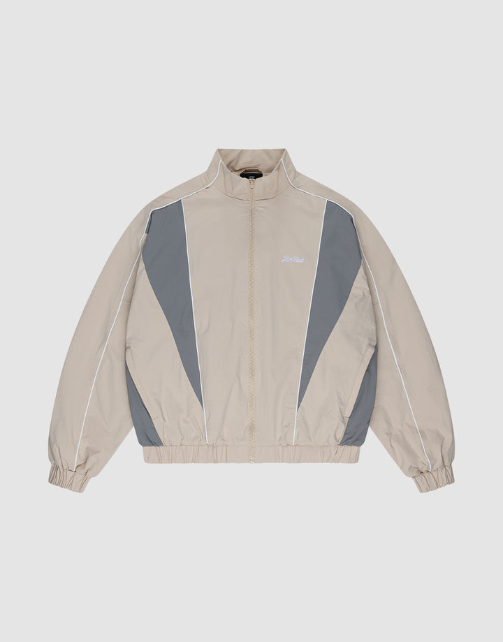 The LIVE FAST DIE YOUNG Basic Nylon Trackjacket in beige and gray features a zip-up front, high collar, white piping, elastic cuffs and hem, and subtle Logo-Stick detail, shown laid flat on a light background. | plain