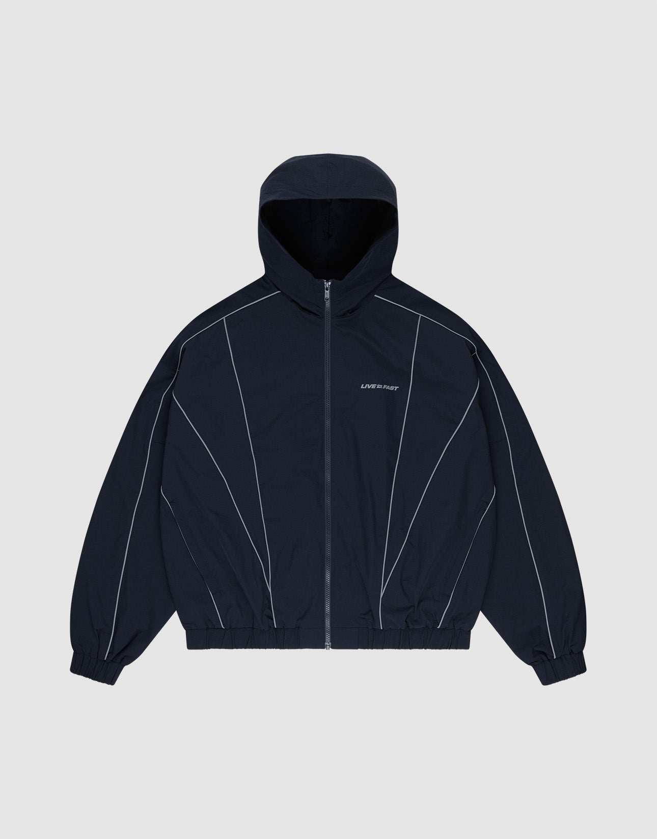 The LIVE FAST DIE YOUNG Live Fast Trackjacket, a navy blue nylon regular fit jacket with front zipper, elastic cuffs and hem, white piping, and reflective "LIPHOP" on the left chest, is displayed flat on a light gray background. | plain