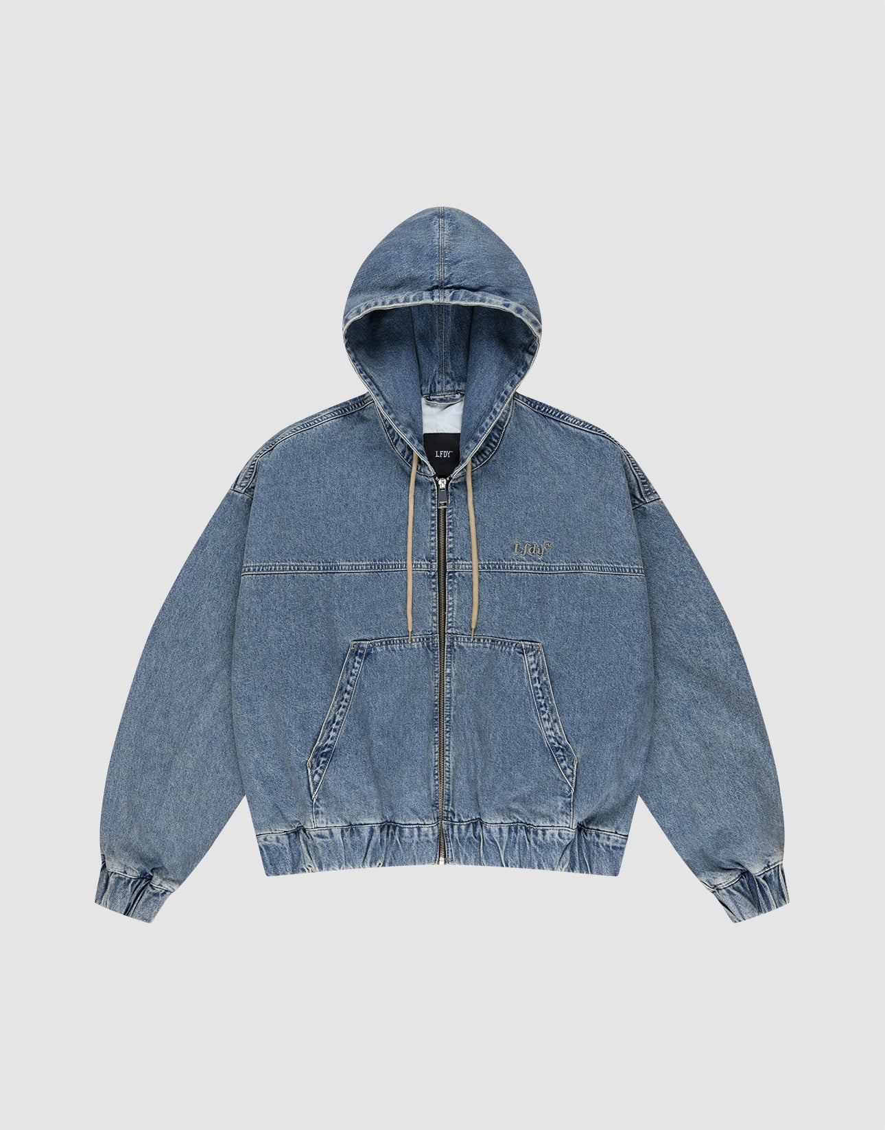 The LIVE FAST DIE YOUNG Denim Hooded Zip is a blue oversized jacket with front zipper, beige drawstrings, and elastic cuffs and hem. Made from 100% Baumwolle for comfort and durability, shown on a plain white background.