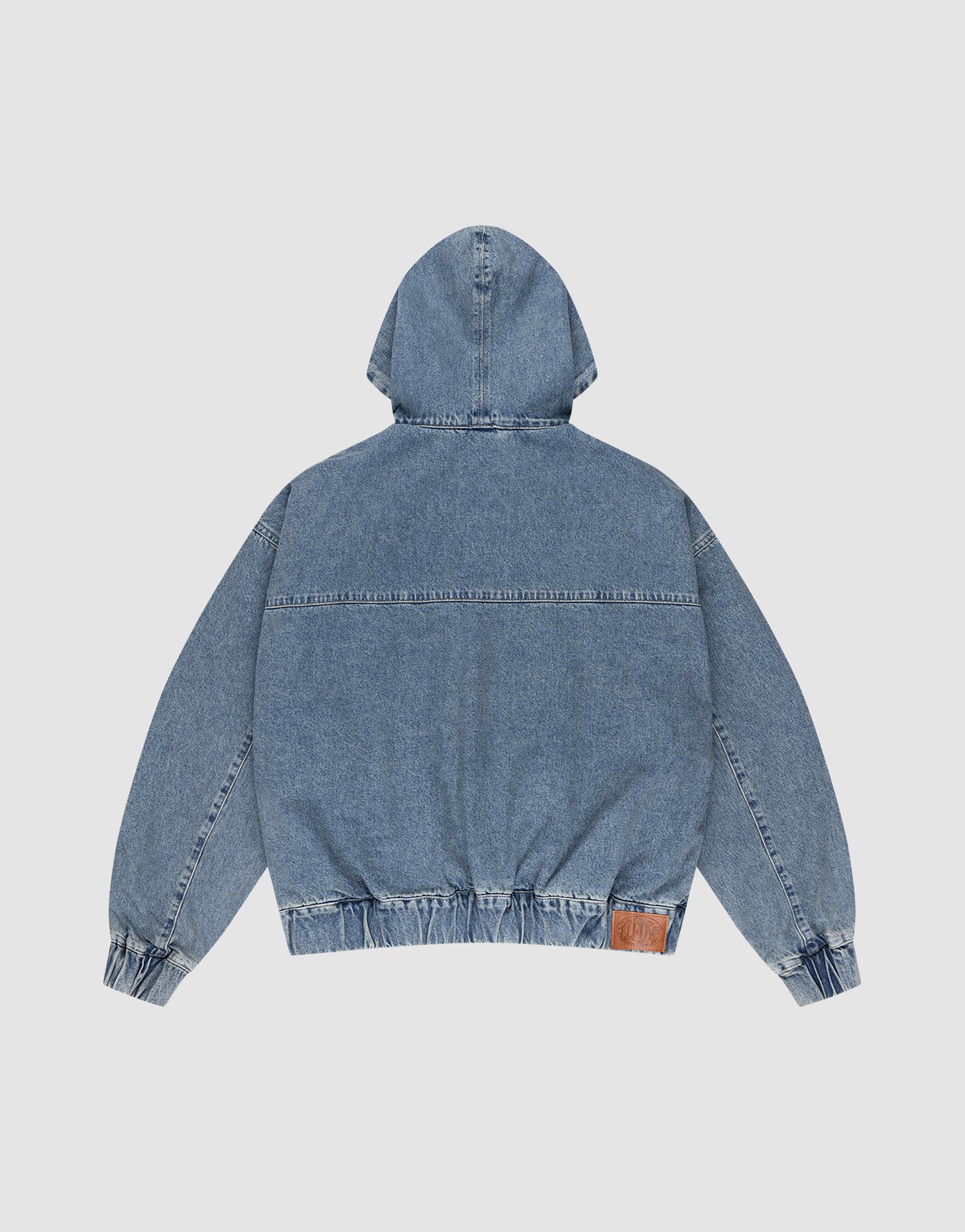 The LIVE FAST DIE YOUNG Denim Hooded Zip is shown from the back, in blue denim with long sleeves, elastic waistband and cuffs, oversize fit, and a brown leather patch on the lower right side.