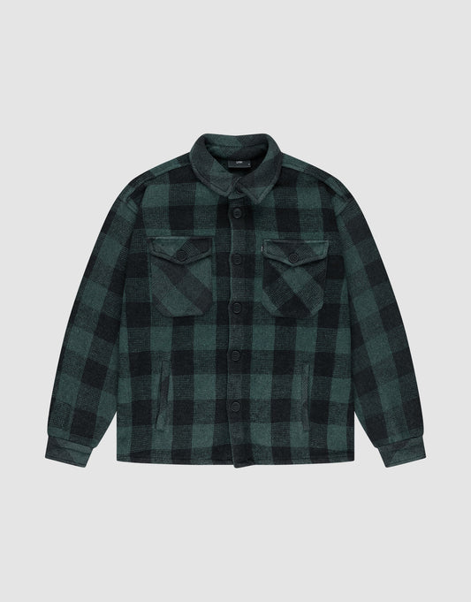 The LIVE FAST DIE YOUNG Heavy Flannel Shacket features green and black plaid, Vintage-Effekt finish, button-down front, flap chest pockets, and side pockets, shown laid flat on a plain light gray background. | plain