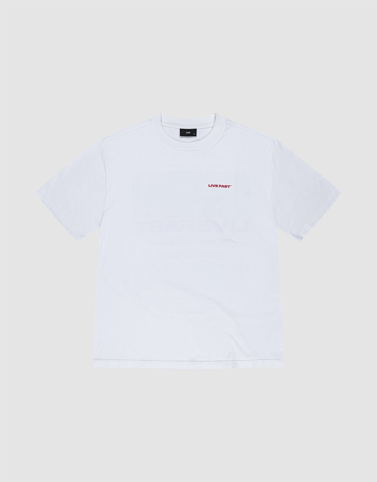 The LFDY Cinema Tee by LIVE FAST DIE YOUNG is an oversized white short-sleeve shirt made from 100% Baumwolle, featuring small red 'LIVE FAST' text on the left chest, shown against a light gray background.