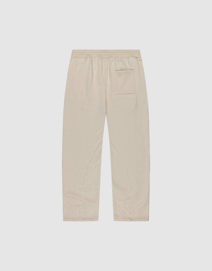 Die LFDY Pleated Jogger von LIVE FAST DIE YOUNG ist eine beigefarbene Hose mit weitem Schnitt, Elastikbund und einer Gesäßtasche, flach auf weißem Hintergrund präsentiert.