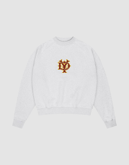 The DY Sweater by LIVE FAST DIE YOUNG is a light gray oversize fit crewneck with ribbed cuffs and hem, raglan sleeves, and a red and gold embroidered NY emblem on the chest, shown on a plain white background.