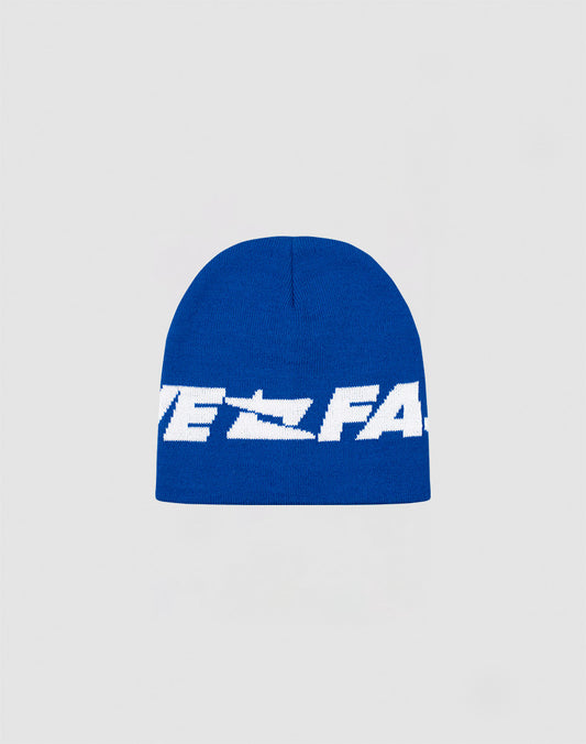 The Live Fast Jacquard Beanie by LIVE FAST DIE YOUNG is a blue knit polyacryl hat with bold white Logo Strick text across the front, shown on a plain light gray background. Style code: LF2410-16488.