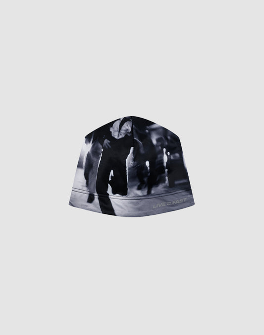 The Live Fast Performance Beanie by LIVE FAST DIE YOUNG features an allover black and white print with a blurred image of people running and the phrase "LIVE 2 FAST" near the brim.