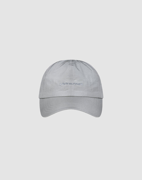 The LFDY Performance Cap by LIVE FAST DIE YOUNG is a light gray, adjustable baseball cap made from lightweight nylon with a curved brim. It features subtle stitching and white embroidered "LIVE FAST" text on the front.