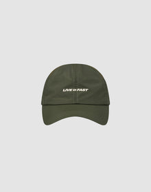 The LFDY Performance Cap by LIVE FAST DIE YOUNG is an olive green nylon cap with white LIVE FAST text on the front, geometric ventilation holes, and adjustable sizing, shown on a light gray background.